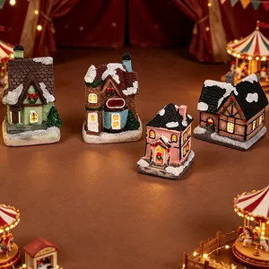 Detailansicht von vier Miniatur-Weihnachtshäusern aus Harz mit Kunstschnee-Effekt