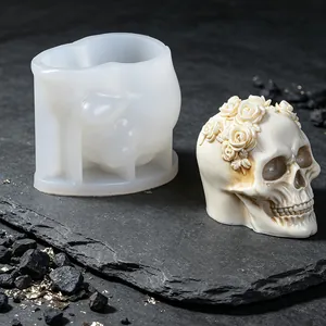 Detail of skull mold with rose wreath design and finished wax candle for Halloween