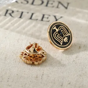 Vintage gold men's lapel pin with black enamel round wing design and filigree back