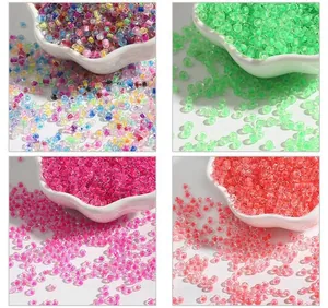 Detailed macro view of 2-4mm dyed core glass seed beads in four vibrant colors for DIY