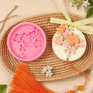 Detailed view of cherry blossom silicone mold next to finished embossed flower wax tablet