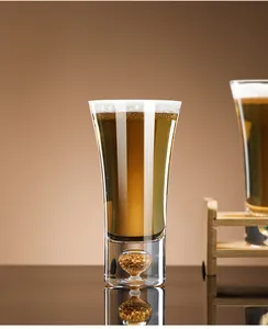 Elegant detail of a premium crystal glass beer mug featuring a decorative gold leaf base.