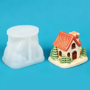 Detailed view of a white silicone mold next to a finished miniature house craft