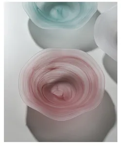 Macro detail of frosted glass fruit bowl featuring artistic wavy flower edges and pink mist texture