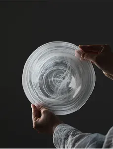 Close-up detail of a creative frosted glass fruit plate with white mist swirl patterns