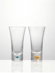 Close-up of crystal beer glasses with decorative turquoise and gold flakes in the base