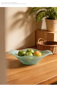 Artistic flower-shaped frosted glass fruit bowl with a misty texture on a warm wooden table