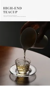 Close-up of tea pouring into a heat-resistant glass teacup with leaf patterns