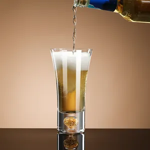 Elegant crystal beer mug with decorative gold leaf base being filled with fresh foamy beer