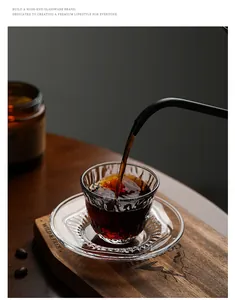 Macro view of hot tea being poured into a textured clear glass teacup with saucer