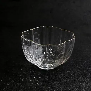 Detailed macro view of a hand-blown glass teacup with hammered texture and scalloped rim