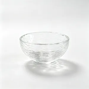 Japanese style clear glass tea cup with hammered ripple texture on white background