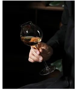 Detailed view of an elegant oblique mouth crystal glass filled with amber liquid