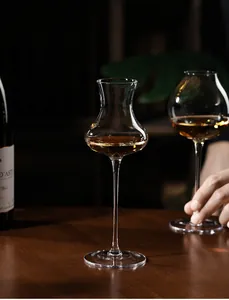 Professional detail view of trumpet-shaped crystal glass cocktail stemware on table