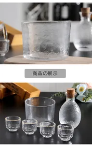 Detailed view of a Japanese hammered glass sake set with a carafe and gold-rimmed cups