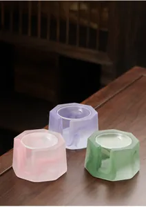 Detailed view of three colorful frosted glass candle holders for zen tea warming decor