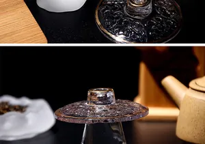 Primer plano del soporte de cristal para tapa de té con borde dorado y diseño grabado.