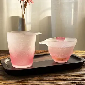Detailed view of elegant pink frosted glass Gaiwan and fairness cup on wooden tray