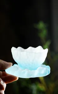 Primer plano de una taza de té de vidrio esmerilado azul con borde de ola artístico