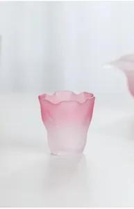 Dettaglio del bordo ondulato e della texture satinata rosa di una tazza da tè giapponese