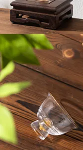 Elegante taza de té de cristal con base de pan de oro sobre una superficie de madera rústica