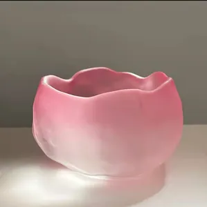 Close-up detail of a pink frosted glass tea cup with an irregular ruffled cloud edge