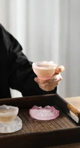 Detalle de una taza de té de cristal esmerilado rosa con una textura de hielo única.