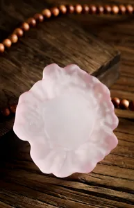 Primer plano de un elegante posavasos de vidrio esmerilado rosa con forma de flor