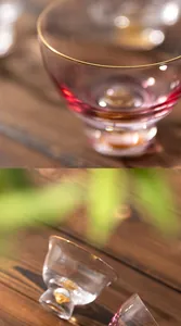 Primer plano de taza de té de cristal con base de pan de oro y un elegante borde dorado.