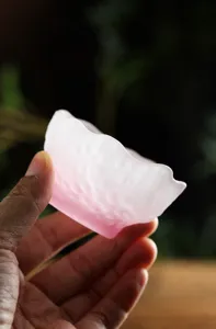 Primer plano de taza de vidrio esmerilado rosa con textura mate fina y delicada