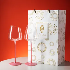 Elegantes Set aus zwei schrägen rosa Kristallweingläsern mit festlicher Geschenktüte