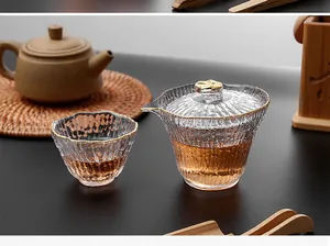 Gros plan détaillé du gaiwan en verre martelé et de la tasse avec finition bord doré