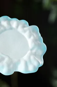 Detalle de un posavasos de vidrio esmerilado con un diseño de borde de montaña.