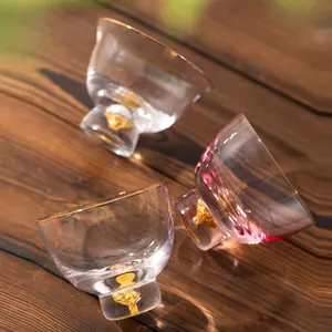 Elegantes tazas de té de cristal con detalles de pan de oro sobre una superficie de madera
