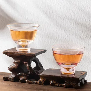 Elegantes tazas de té de cristal con base de pan de oro en soporte de madera