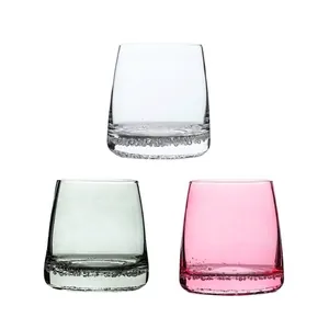Set of three modern whiskey glasses with unique bubble base in clear, grey and pink.