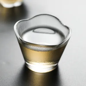 Japanese style hammered crystal glass tea cup with wavy rim shown with golden tea liquid