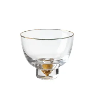 Elegante taza de té de cristal con borde dorado y decoración interna de pan de oro