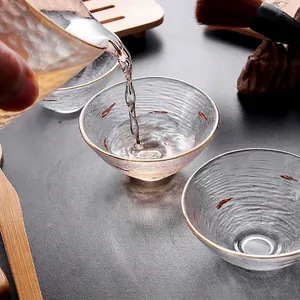 Elegante taza de té de cristal con borde dorado y superficie texturizada para el té