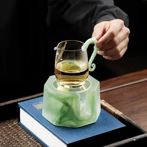 Elegant Zen-style glazed glass tea warmer set with green handle pitcher on a wooden tray