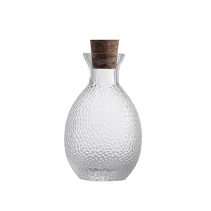 Elegant Japanese hammered glass sake decanter with cork stopper on white background