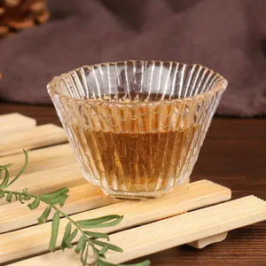 Handmade Japanese style ribbed glass Kung Fu tea tasting cup on a natural bamboo mat
