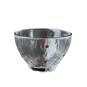 Japanese-style hammered glass tea cup with gold rim and dots