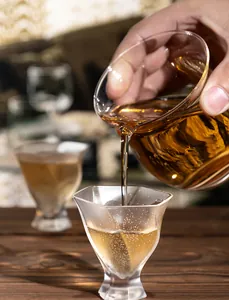 Detailed view of tea pouring into a handmade bubble textured crystal glass cup.