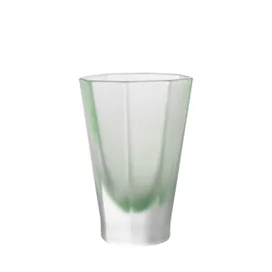 Minimalist octagonal heat-resistant glass cup with green swirl pattern on white background
