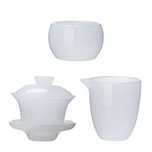 Elegant white jade glass Kung Fu tea set including Gaiwan, fair cup, and tasting cup.