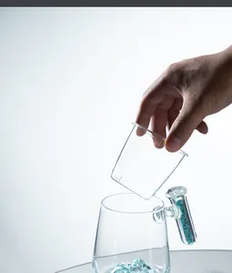 Close-up of a clear glass coffee mug with a stone-filled handle and infuser