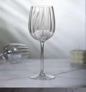 Elegant vertical striped crystal Bordeaux wine glass on a marble table with soft lighting