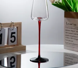 Primo piano squisito dell'elegante stelo rosso su un flauto da champagne in cristallo