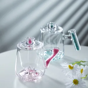 Elegant transparent glass coffee mug with lid and mountain base featuring crystal handle